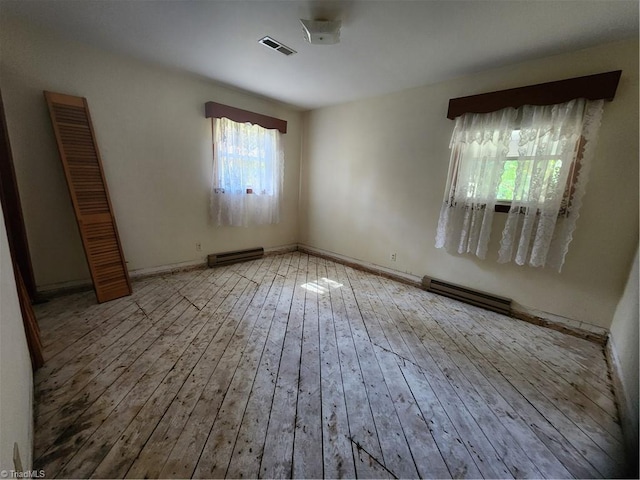 empty room with a baseboard radiator and light hardwood / wood-style flooring