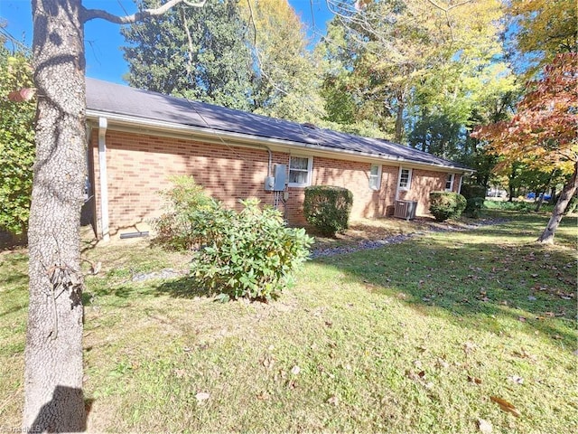 view of front of house with central AC and a front lawn