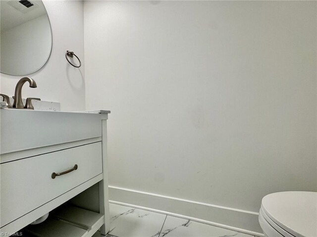 1101 Forrest St, High Point, NC 27262 - bathroom with marble finish floors, vanity, toilet, and baseboards