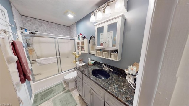 full bathroom featuring vanity, toilet, and combined bath / shower with glass door