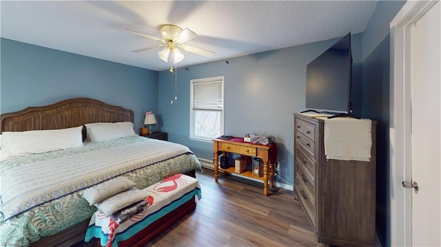 bedroom with ceiling fan, hardwood / wood-style flooring, and a textured ceiling