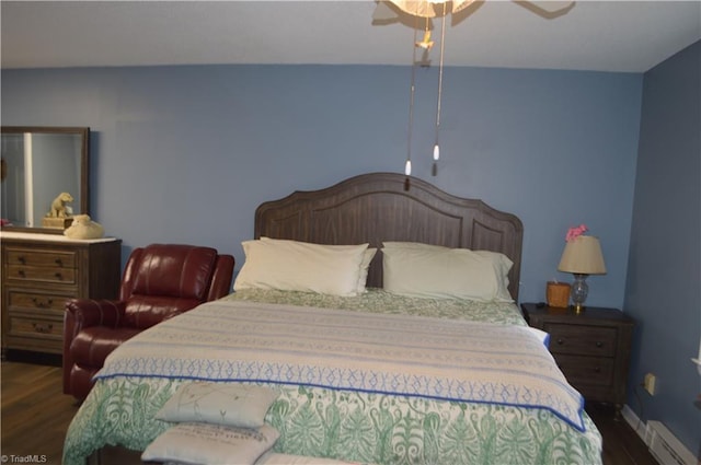 bedroom featuring ceiling fan, a baseboard heating unit, and dark hardwood / wood-style floors