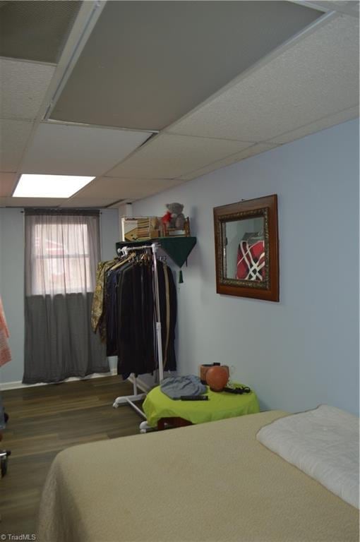 bedroom with dark hardwood / wood-style flooring and a drop ceiling