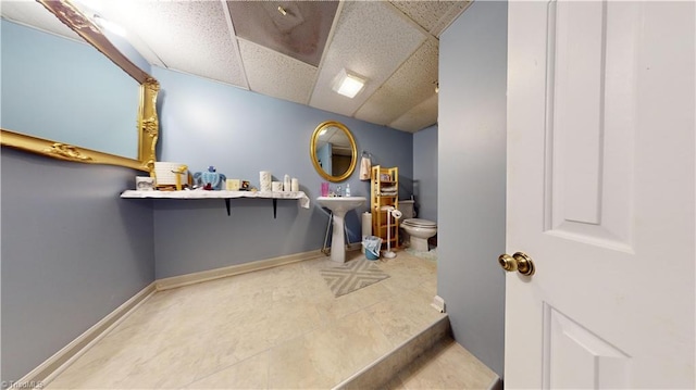 interior space featuring sink and a drop ceiling