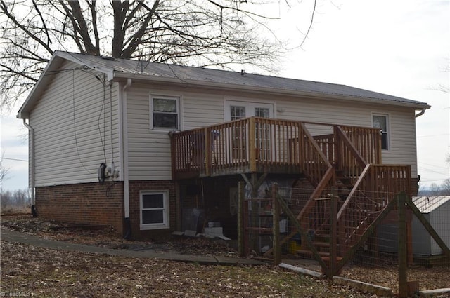 rear view of property featuring a wooden deck