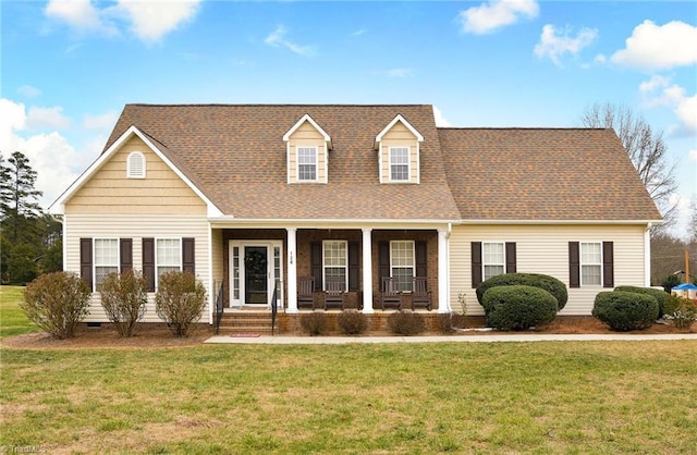 cape cod-style house featuring covered porch and a front lawn