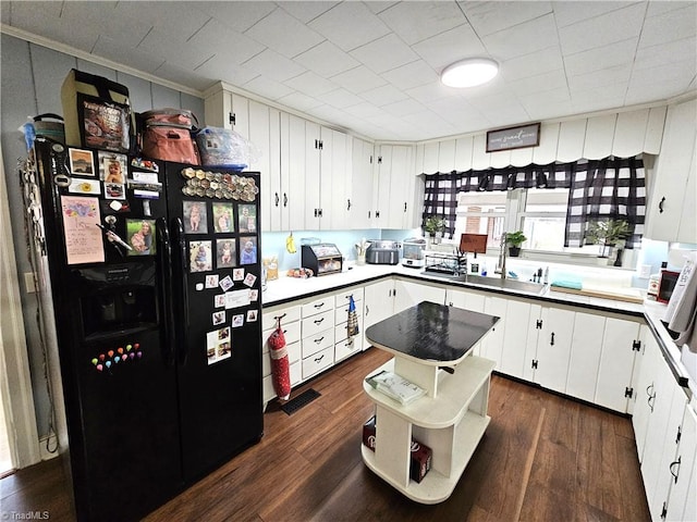 kitchen with white cabinets and black fridge