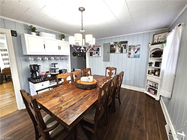 dining room with dark hardwood / wood-style floors and an inviting chandelier