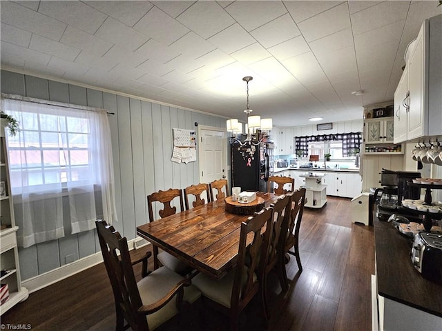 dining space featuring dark hardwood / wood-style flooring, a notable chandelier, and a wealth of natural light