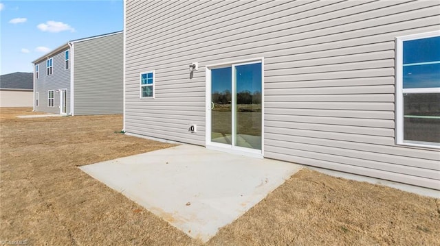 view of side of home with a yard and a patio area