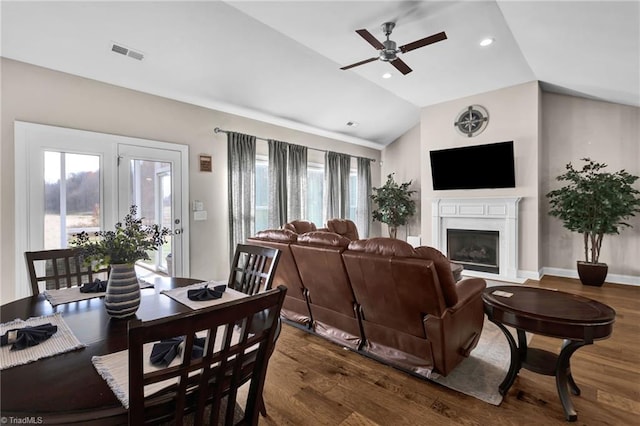 living room with dark wood-type flooring, plenty of natural light, lofted ceiling, and ceiling fan