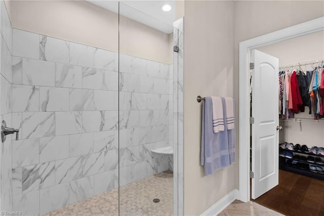 bathroom featuring a tile shower and hardwood / wood-style flooring