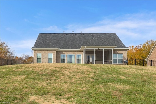 rear view of property with a sunroom and a lawn