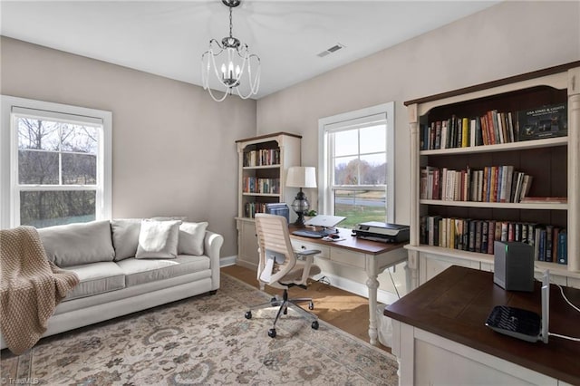 office area featuring plenty of natural light, hardwood / wood-style floors, and a notable chandelier