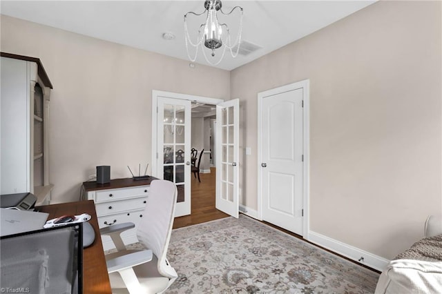 office space with french doors, an inviting chandelier, and hardwood / wood-style floors