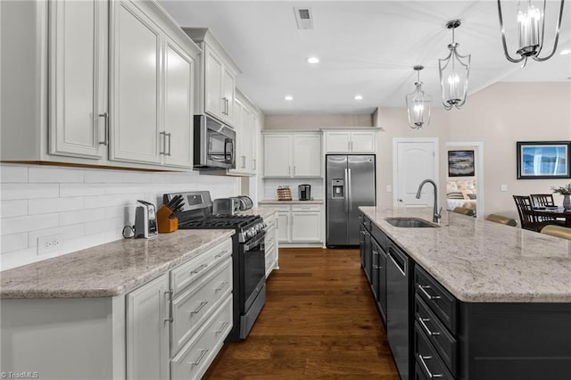 kitchen with white cabinetry, sink, hanging light fixtures, a center island with sink, and appliances with stainless steel finishes