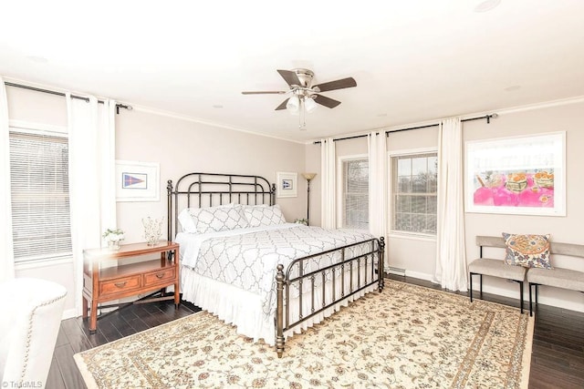 bedroom featuring crown molding, dark wood-type flooring, and ceiling fan