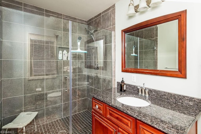 bathroom with vanity, toilet, and a shower with door