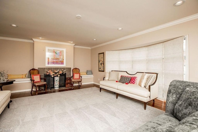 living room with hardwood / wood-style flooring, crown molding, and a tile fireplace