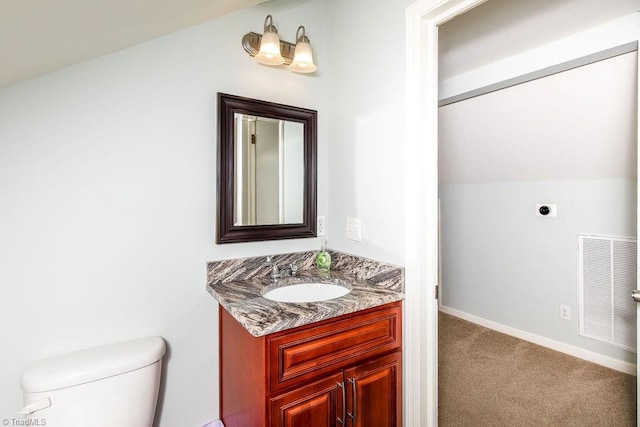 bathroom featuring vanity, vaulted ceiling, and toilet