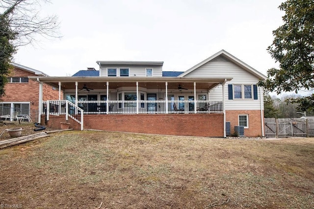 rear view of house with a lawn, ceiling fan, and covered porch