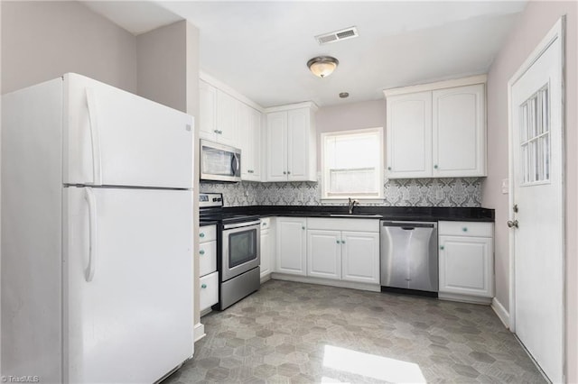 kitchen featuring sink, stainless steel appliances, white cabinetry, and tasteful backsplash