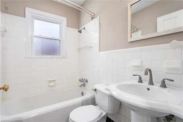 full bathroom with sink, tile walls, toilet, and tiled shower / bath