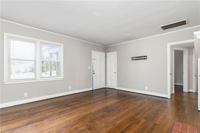 spare room featuring dark wood-type flooring and ornamental molding