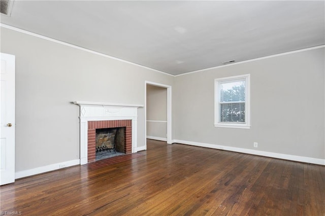 unfurnished living room featuring a brick fireplace, ornamental molding, and dark wood-type flooring