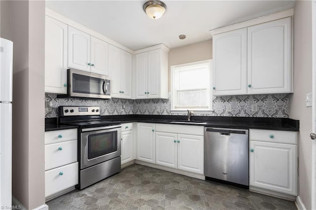 kitchen featuring sink, white cabinetry, backsplash, and appliances with stainless steel finishes