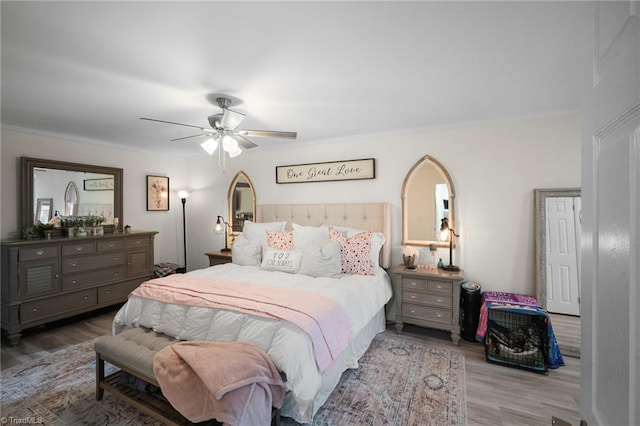 bedroom with ornamental molding, a ceiling fan, and wood finished floors