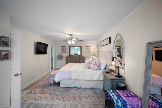 bedroom featuring a ceiling fan, crown molding, baseboards, and wood finished floors