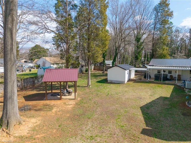 view of yard with a shed, an outdoor structure, and fence