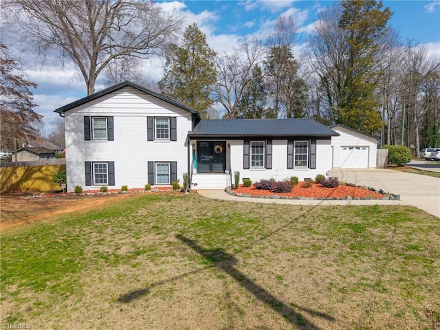 tri-level home featuring brick siding, a front lawn, fence, metal roof, and a garage