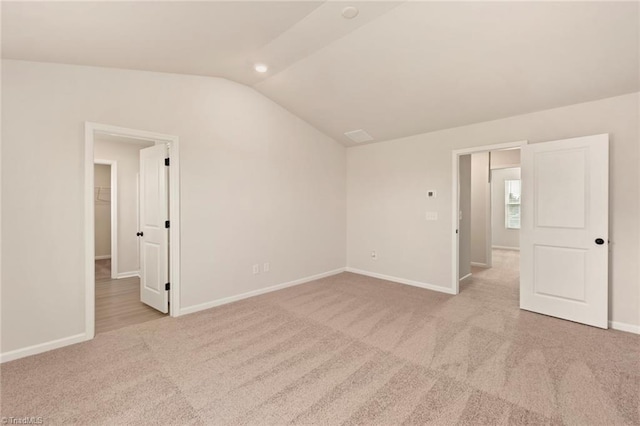 interior space featuring lofted ceiling and light carpet