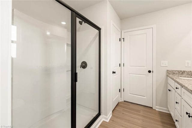 bathroom featuring hardwood / wood-style floors, vanity, and walk in shower