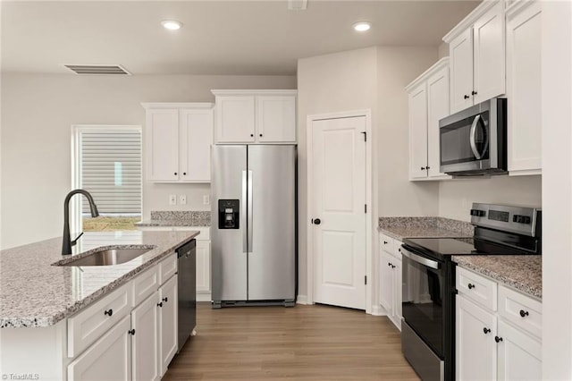 kitchen with light hardwood / wood-style flooring, stainless steel appliances, white cabinetry, and sink