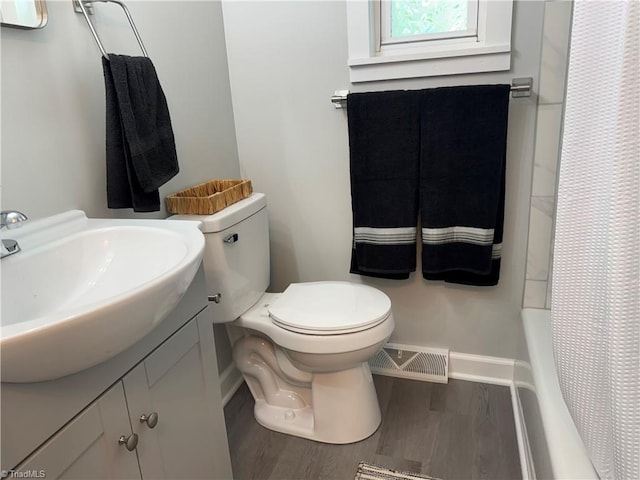 full bath with visible vents, wood finished floors, baseboards, vanity, and toilet
