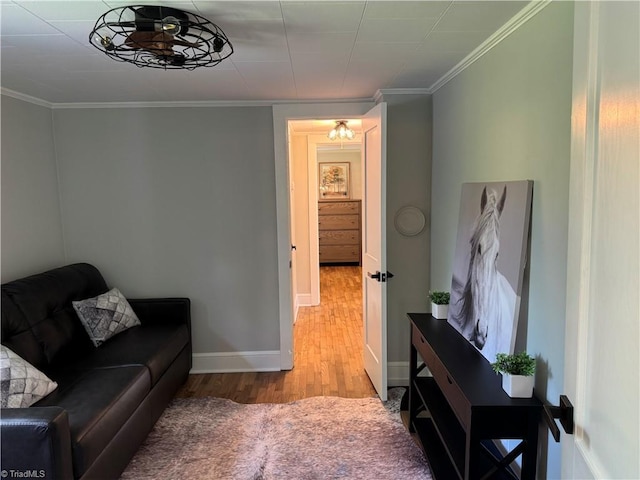 living room featuring crown molding, baseboards, and wood finished floors