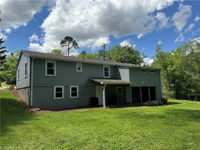 rear view of house featuring a lawn and central air condition unit