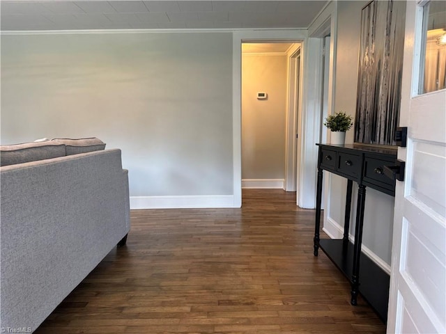 hall featuring baseboards, ornamental molding, and dark wood-style flooring