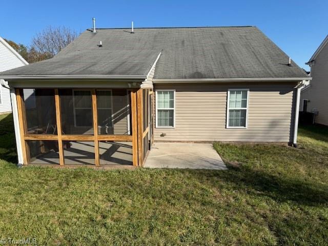 rear view of house with a lawn, a sunroom, and a patio area