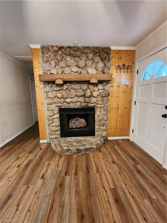 1129 Foxtrot Ct, King, NC 27021 - unfurnished living room featuring ornamental molding, baseboards, wood finished floors, and a stone fireplace