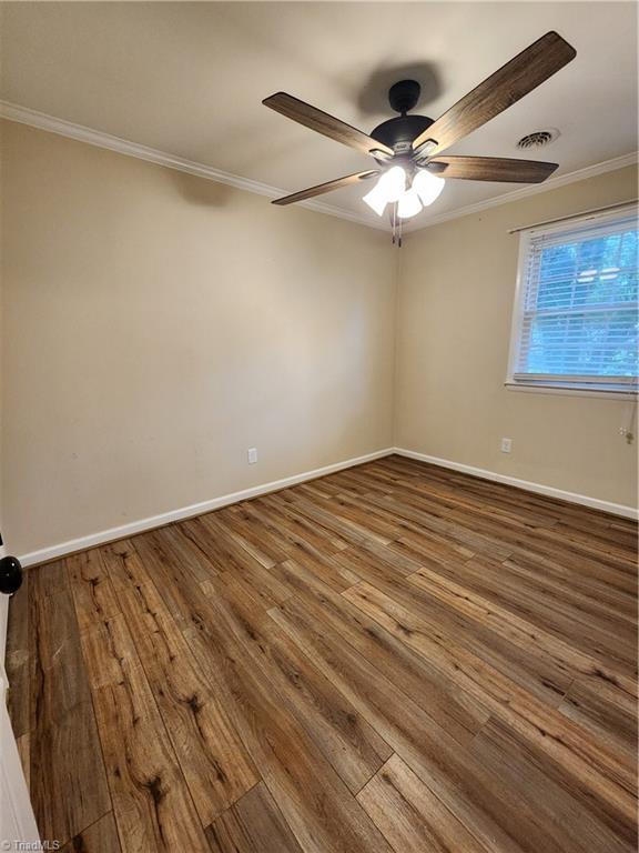 1129 Foxtrot Ct, King, NC 27021 - spare room with ornamental molding, a ceiling fan, hardwood / wood-style floors, and baseboards