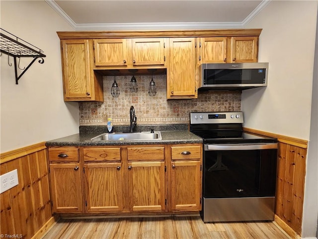 1129 Foxtrot Ct, King, NC 27021 - kitchen with appliances with stainless steel finishes, a sink, dark countertops, light wood finished floors, and a wainscoted wall