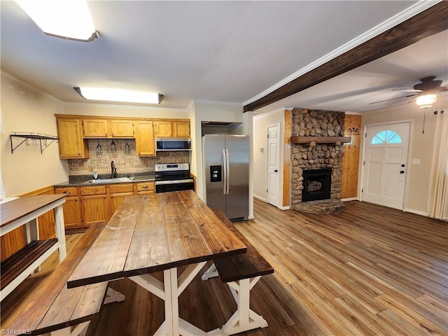 1129 Foxtrot Ct, King, NC 27021 - kitchen featuring appliances with stainless steel finishes, a sink, backsplash, wood finished floors, and dark countertops