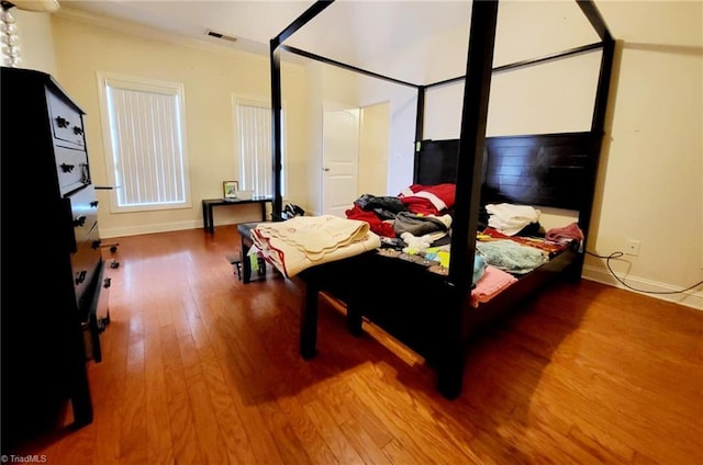 bedroom with hardwood / wood-style flooring and ornamental molding