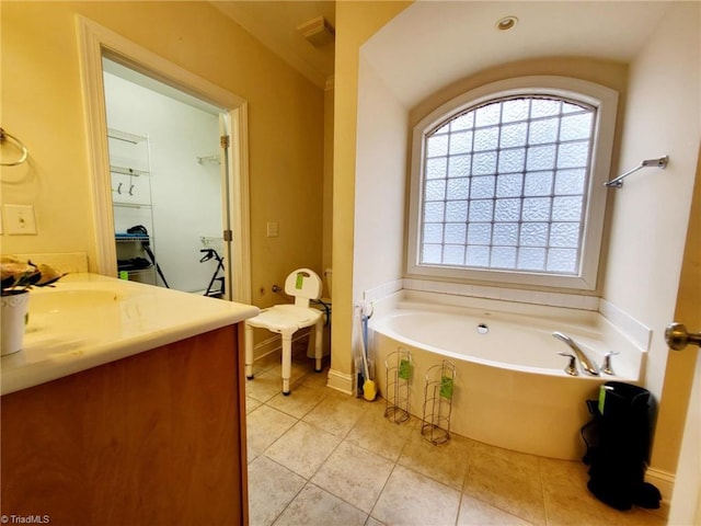 bathroom featuring vanity, tile patterned flooring, and a tub