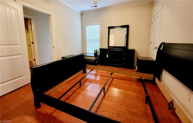 bedroom featuring hardwood / wood-style flooring and crown molding