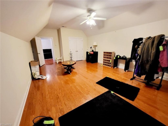 workout room with wood-type flooring, lofted ceiling, and ceiling fan